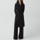 woman wears black belted trench coat