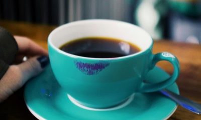 teal coffee cup with a lipstick stain on the rim