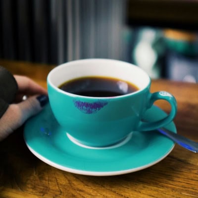 teal coffee cup with a lipstick stain on the rim