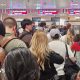 A crowd of passengers waiting in the passport control queue at Milan Bergamo airport on 16 April,  with four check-in desks visible.
