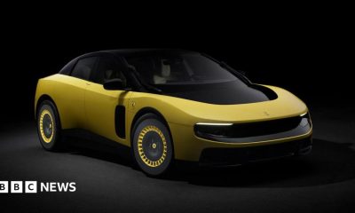A promotional image of a yellow version of the electric Ferrari Luce, photographed in a dark studio.