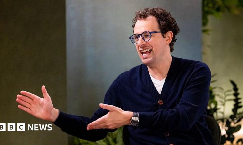 Dario Amodei, co-founder and chief executive officer of Anthropic, speaking during an interview in a room decorated with plants