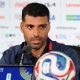 Mehdi Taremi speaks into a microphone while conducting a press conference