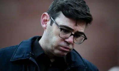 Andy Burnham looking down towards the floor, seemingly in the middle of blowing air out his mouth