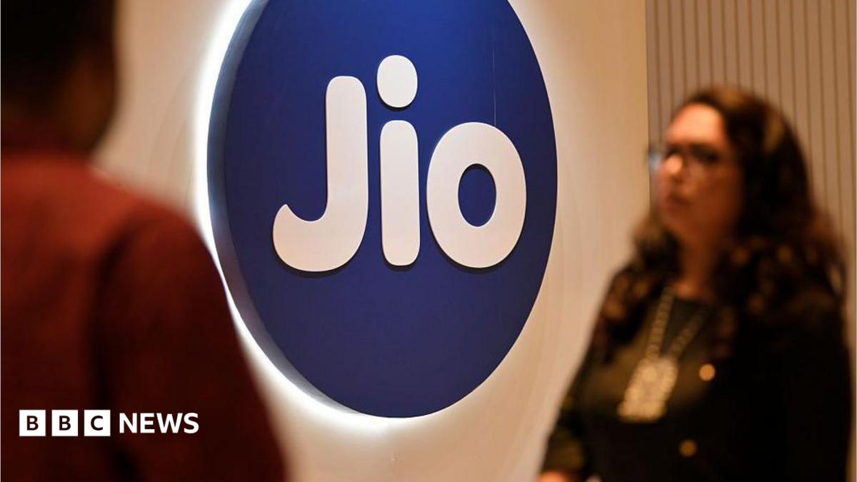 People walk past a Jio signage at an event in Mumbai, India, on 3 May 2025.