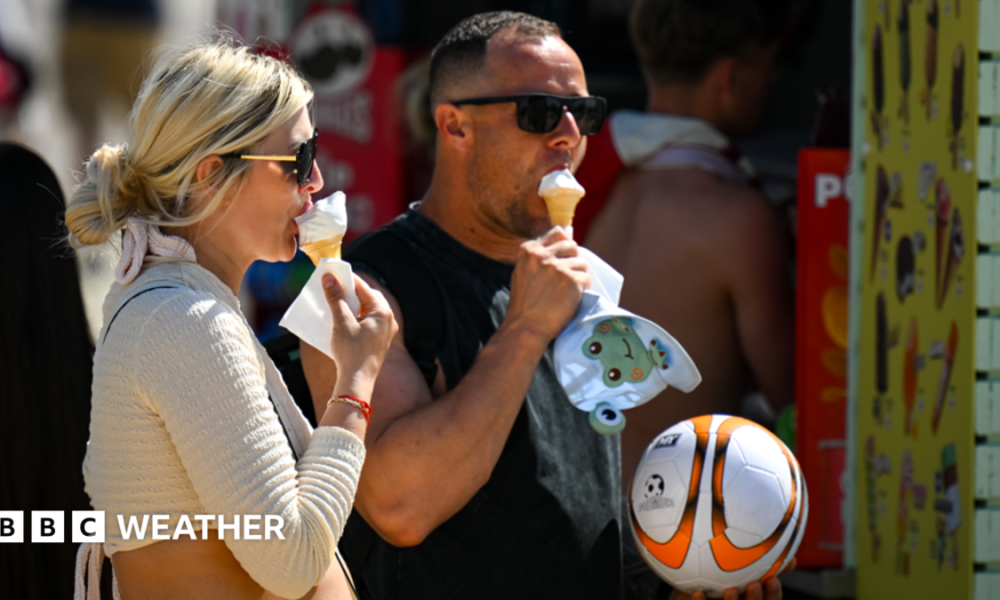 A man and a woman eating ice cream cones in the sunshine