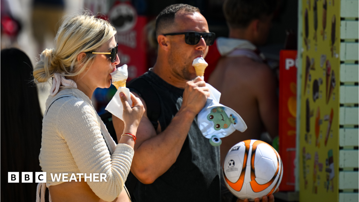 A man and a woman eating ice cream cones in the sunshine