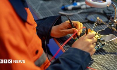 A female worker testing a circuit board in a workshop