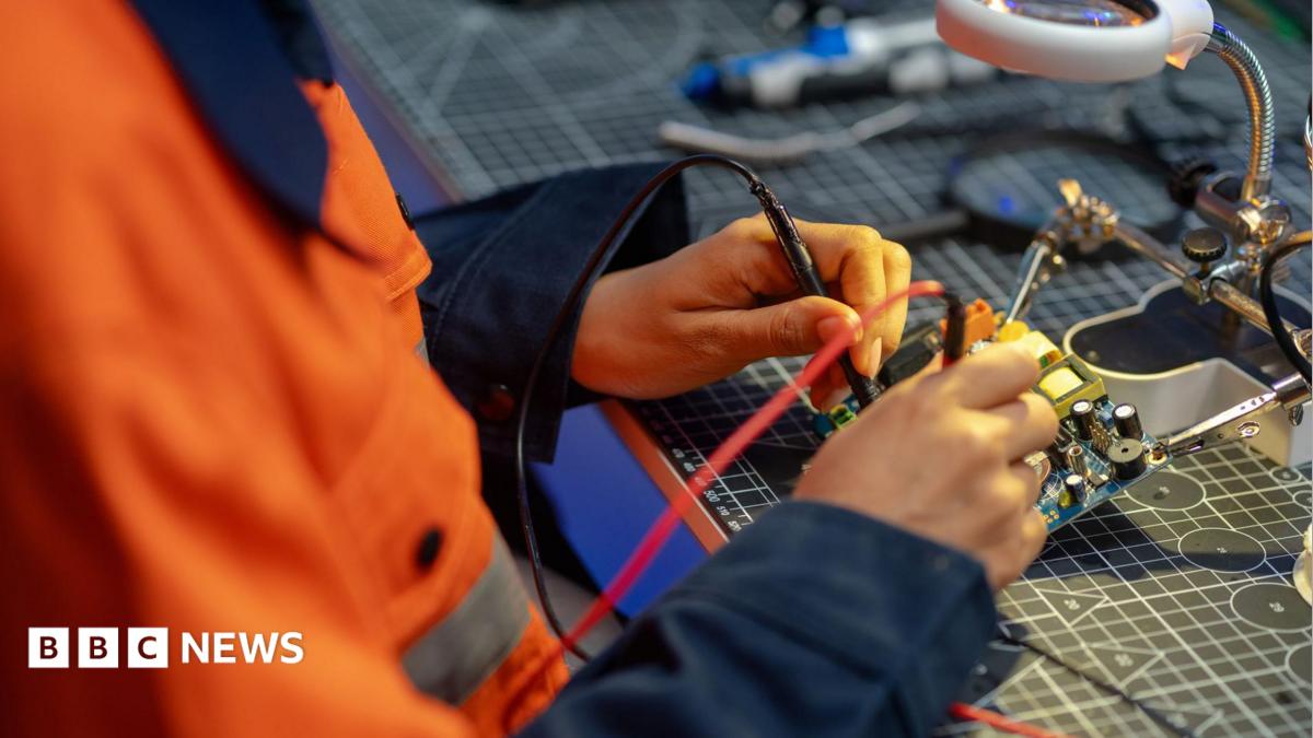 A female worker testing a circuit board in a workshop