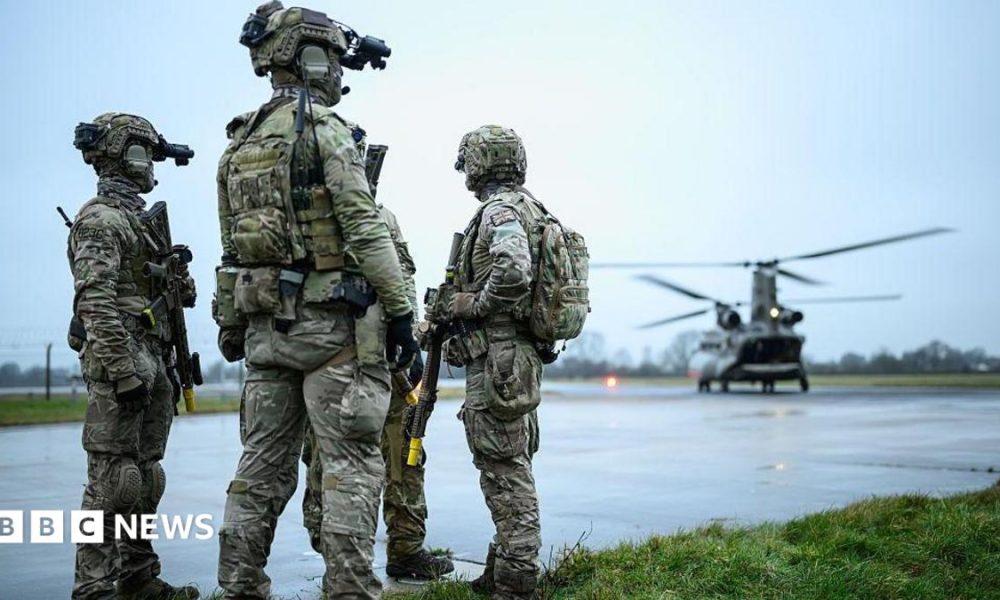 British special forces on a runway with a helicopter nearby
