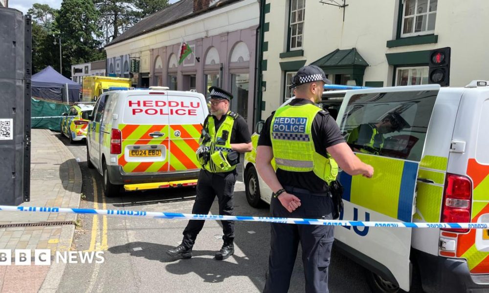 Police officers standing next to a cordoned-off area in Church Street, Welshpool