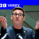 Andy Burnham holds his hands up in front of him as he delivers a speech