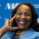 Lisa D. Cook, a member of the Board of Governors of the Federal Reserve, smiles while holding her hand against her face. She is wearing a blue suit and speaks at The Capital Hilton during the 42nd annual National Association for Business Economics Economic Policy Conference on February 24, 2026 in Washington, DC.