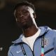 Bukayo Saka in a pale blue England tracksuit