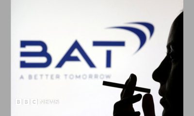 Silhouette of a person holding a cigarette in front of a dark blue BAT logo on a white background