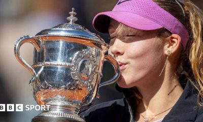 A close-up of Mirra Andreeva's jacket bearing the phrase 'I want to thank myself' while she holds the French Open winners' trophy