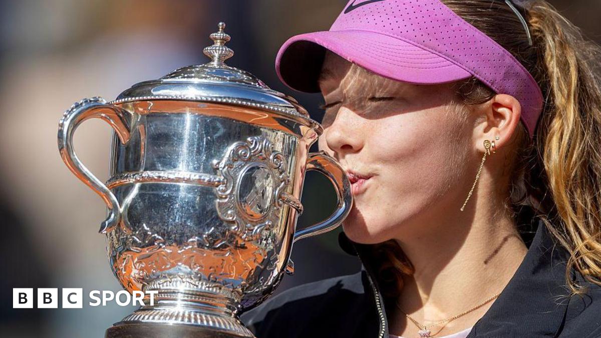 A close-up of Mirra Andreeva's jacket bearing the phrase 'I want to thank myself' while she holds the French Open winners' trophy