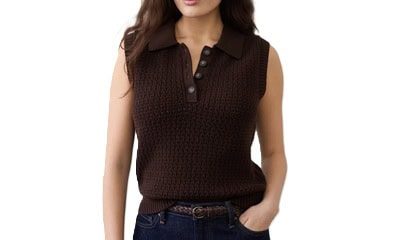 A woman wearing dark blue jeans, a brown belt, and brown crochet sleeveless top