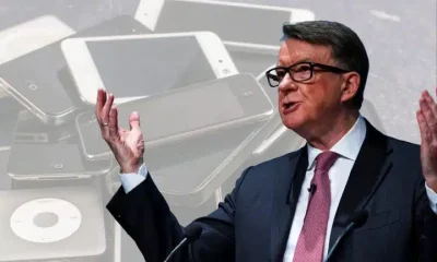 Peter Mandelson in front of pictures of mobile devices