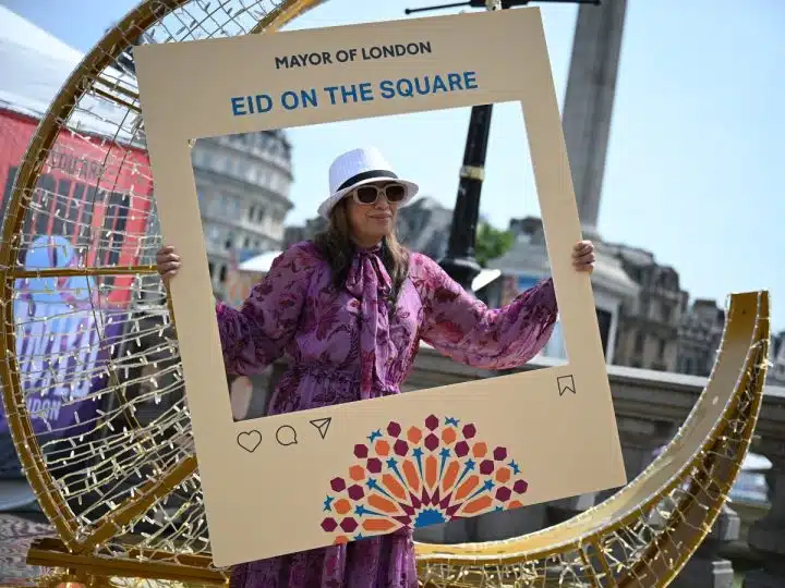 A festival goer poses in a photo frame at Eid on the Square 2026