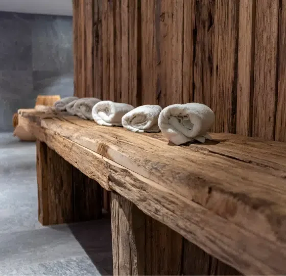 Folded Beige Towels Ready for Use in Spa on Rustic Wooden Table