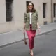 MUNICH, GERMANY - APRIL 28: Annette Weber is seen wearing an olive green cotton field jacket with a relaxed fit, button front closure and multiple flap patch pockets from AG Jeans; a white cotton crew neck top with a fitted silhouette from Brunello Cucinelli; a red satin longuette skirt with a straight silhouette and white polka dot print from Glamometer x Seidensticker; brown calfskin