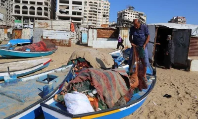 Gazan fishermen patch up dinghies with door frames to keep themselves afloat