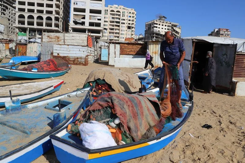 Gazan fishermen patch up dinghies with door frames to keep themselves afloat