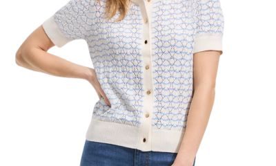 A woman wearing a blue-and-white striped, short-sleeved cardigan and blue jeans