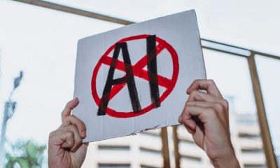 Hands holding a placard with AI crossed out SAG-AFTRA and Equity AI campaigns