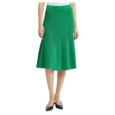A woman wearing a bright green skirt and black slingbacks