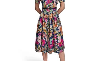 A woman wearing a colorful floral dress and black heels