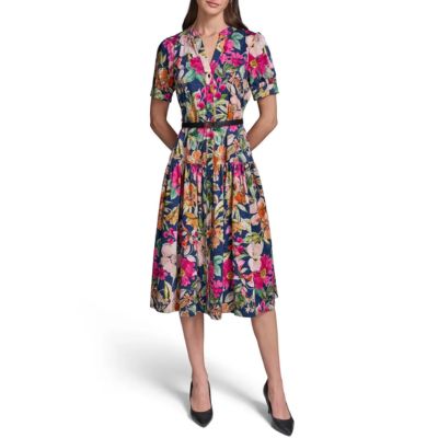 A woman wearing a colorful floral dress and black heels