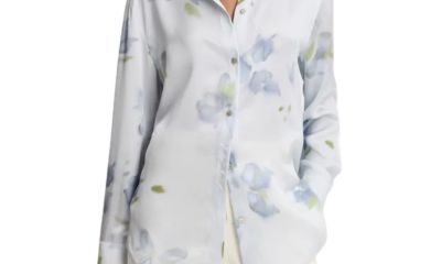 A woman wearing a blue floral blouse and cream-colored pants