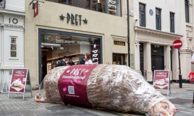 A giant model chicken, labelled as a FrankenWrap, lies on the pavement outside a branch of Pret A Manger