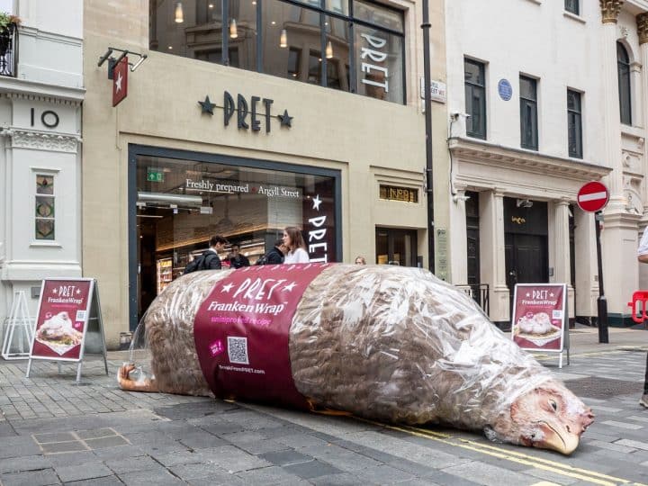 A giant model chicken, labelled as a FrankenWrap, lies on the pavement outside a branch of Pret A Manger