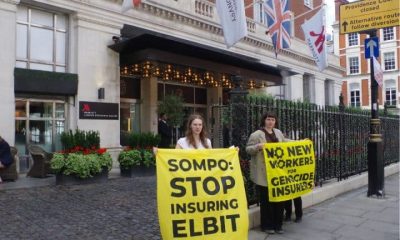 Protesters against Sompo Insurance hold banners saying: Sompo: Stop Insuring Elbit and No New Workers For Genocide Insurers