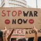 Hands holding a home made placard saying Stop War Now
