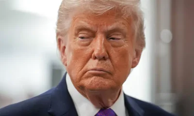 US president Donald Trump with his mouth slightly curled, looking stern with his gaze down and slightly away