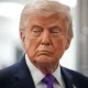US president Donald Trump with his mouth slightly curled, looking stern with his gaze down and slightly away