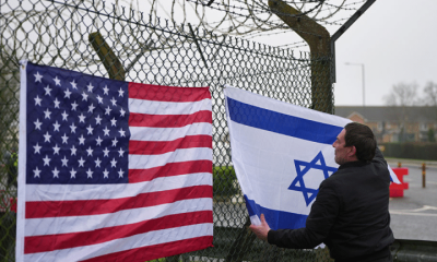 People who describe themselves as patriots display US and Israel flags as they set up their counter protest ahead of the protest by CND at RAF Fairford on March 7, 2026 in Fairford, England.