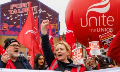 Unite members protest over Tata Steel with Sharon Graham up front, wearing a flourescent jacket and holding her fist in the air