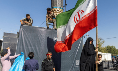 A woman is seen holding the Iranian Flag on June 15, 2026 in Tehran, Iran. According to reports, the U.S. and Iran have signed a preliminary agreement to end the war and open the Strait of Hormuz. The UAE is alleged to have agreed to unlock funds frozen in foreign banks under US sanctions for Iran.
