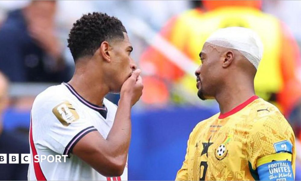 England's Jude Bellingham covers his mouth as he speaks with Ghana's Jordan Ayew