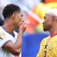 England's Jude Bellingham covers his mouth as he speaks with Ghana's Jordan Ayew