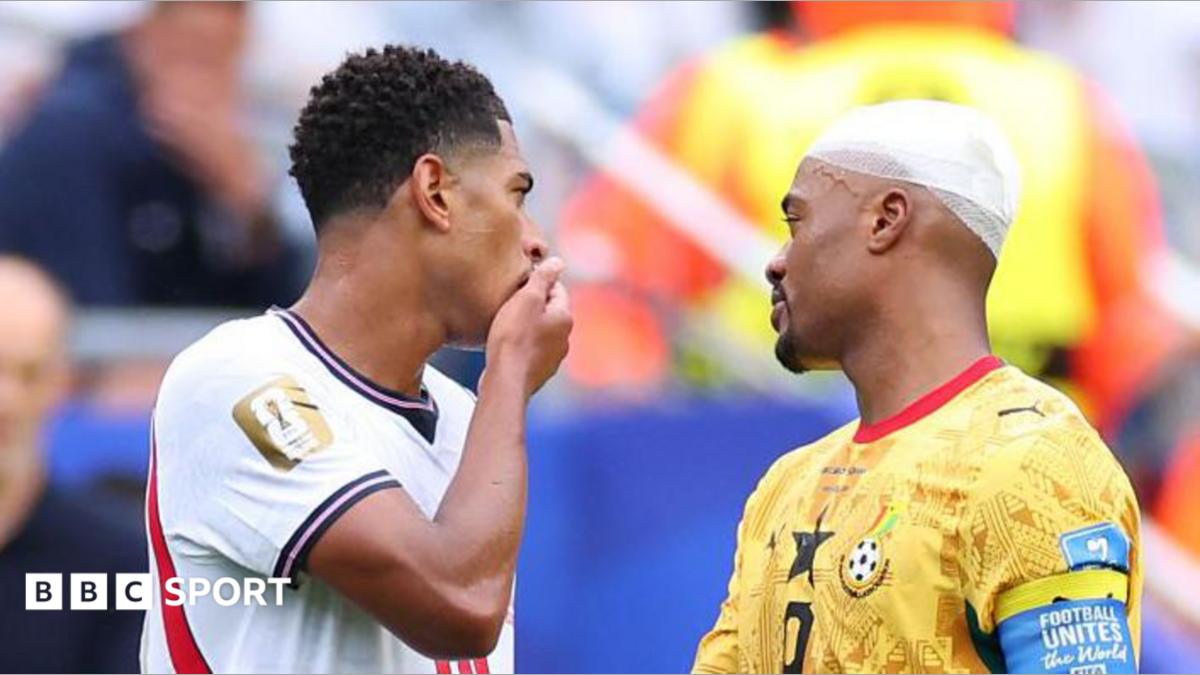 England's Jude Bellingham covers his mouth as he speaks with Ghana's Jordan Ayew