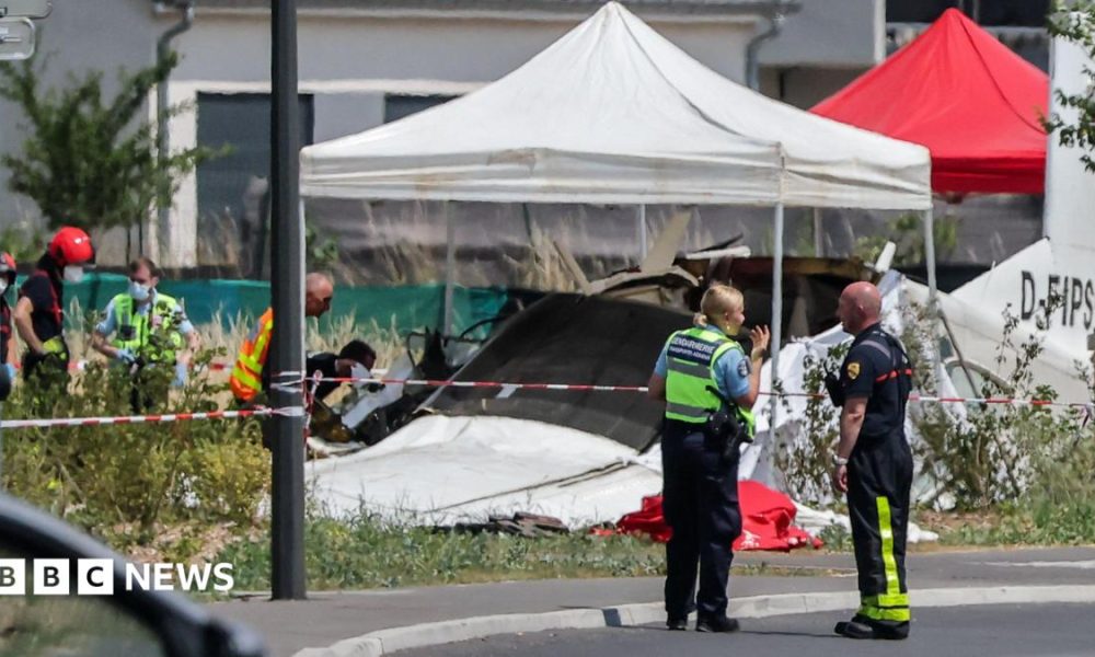 Emergency service workers speak to each other as the attend a light aircraft crash site