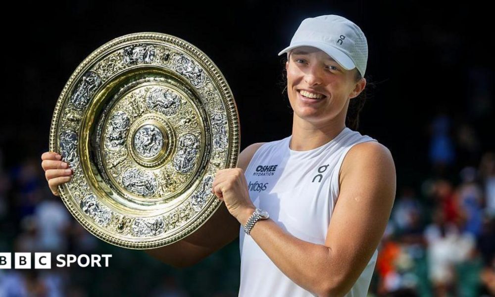 Iga Swiatek holding the Wimbledon women's singles final trophy