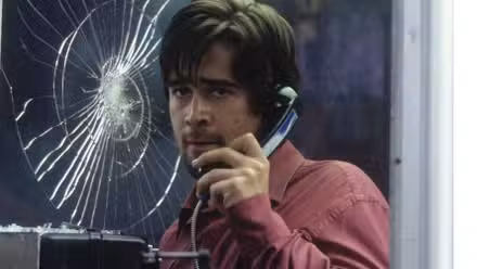 Colin Farrell as Stu Shpeard inside a booth holding a phone to his ear and looking scared in Phone Booth