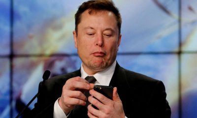 Elon Musk looks at his mobile phone